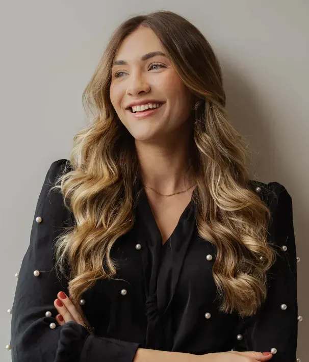 Jéssica Bilibio sorrindo, de braços cruzados